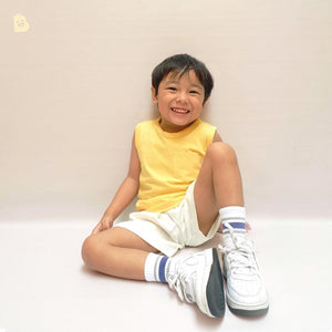 A boy in a sleeveless pocket tee